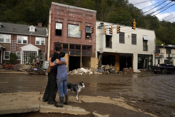 Resident Anne Schneider, right, hugs her friend, Eddy Sampson, as they survey damage caused by Hurricane Helene on Oct. 1, 2024, in Marshall, N.C. (AP Photo/Jeff Roberson, File)