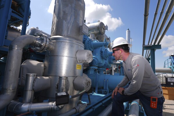 BKV Carbon Ventures project manager Spencer Crouch looks at a compression station that's part of a carbon capture and sequestration facility in Bridgeport, Texas, Thursday, May 29, 2025. (AP Photo/LM Otero)