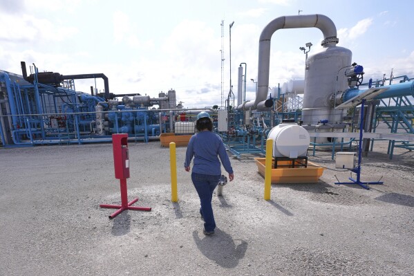 BKV Carbon Ventures senior facility engineer Laura Mamazza walks at a compression station at a carbon capture and sequestration facility in Bridgeport, Texas, Thursday, May 29, 2025. (AP Photo/LM Otero)