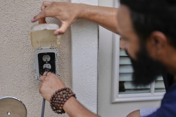 Bhavin Misra plugs his Craftstrom Solar unit into an outlet at his home Tuesday, Aug. 5, 2025, in Houston. (AP Photo/David J. Phillip)