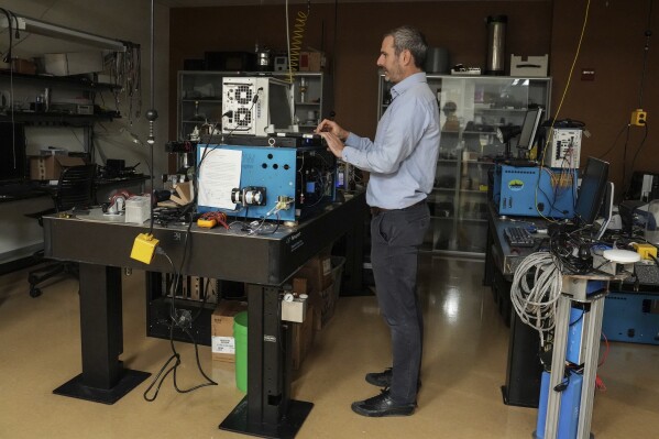 Francois Ribalet, a research associate professor at the University of Washington's School of Oceanography, works atop a SeaFlow, an instrument used to detect Prochlorococcus, in his Seattle lab Friday, Sept. 5, 2025. (AP Photo/Annika Hammerschlag)